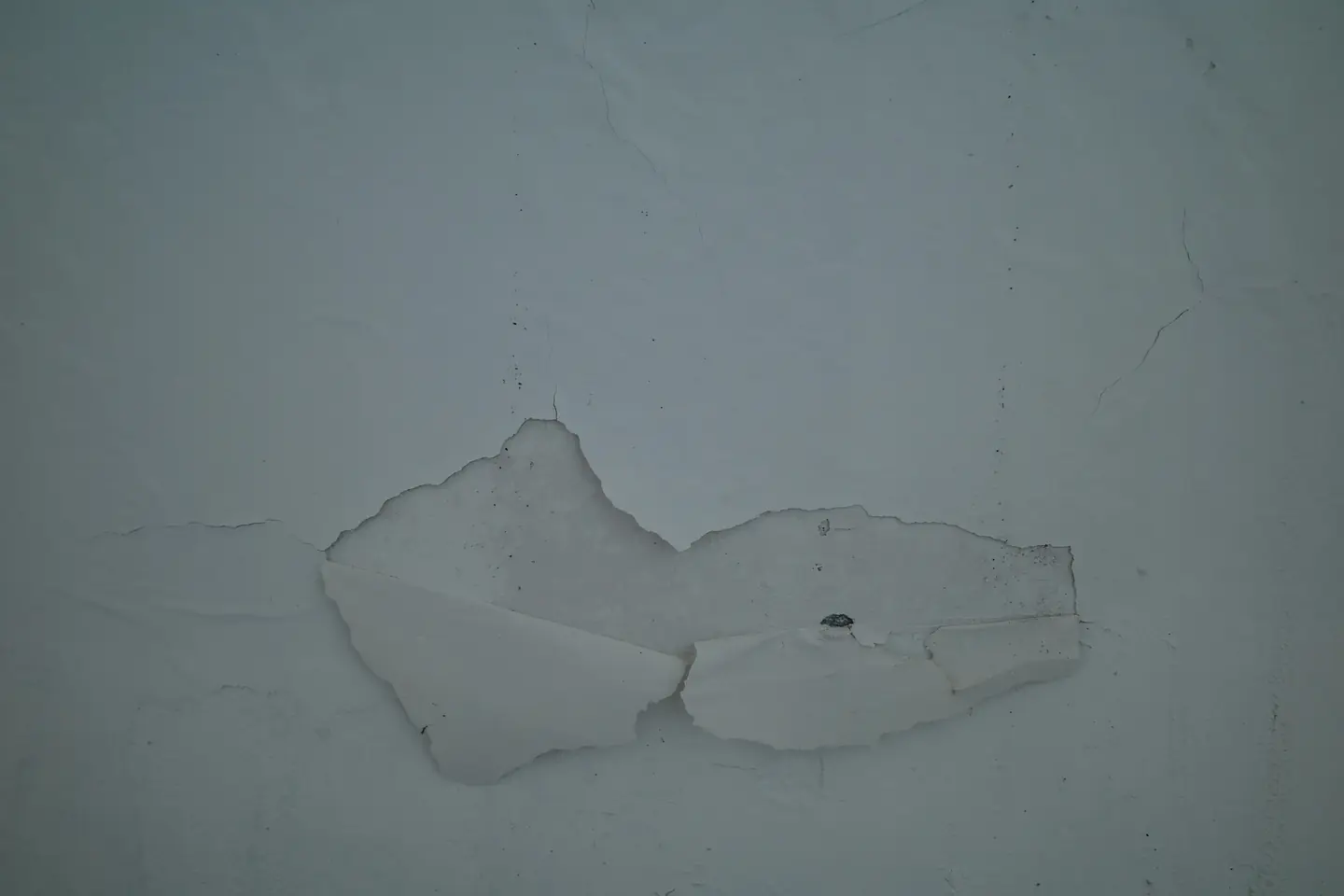 Paint peeling away from a wall that soaked up water from a leak