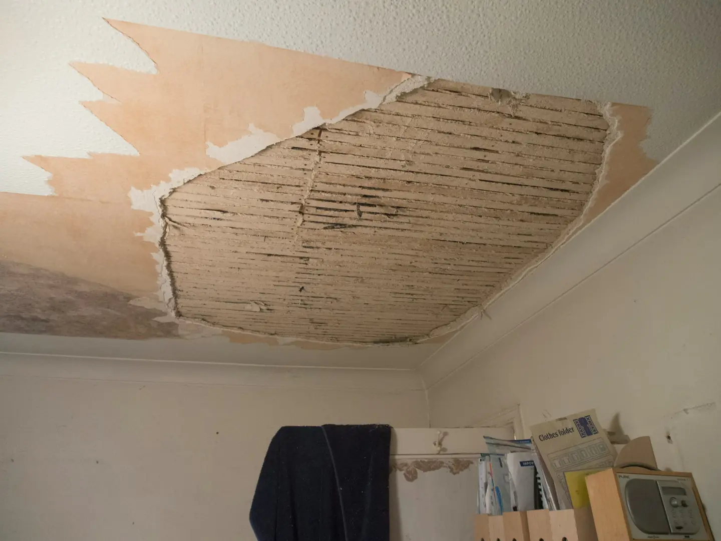 A ceiling where water-soaked drywall has fallen away after a hidden leak
